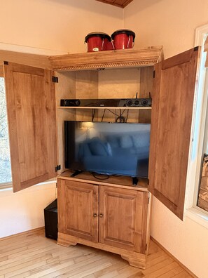 A wooden entertainment unit with a flat-screen TV, sound system, and storage cabinets. - Wonderful views, wrap around deck, 4 bedrooms, May Discount (Waynesville)
