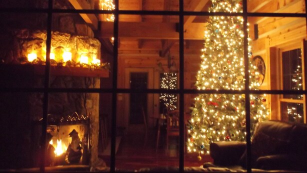 A cozy cabin interior with a large Christmas tree, a fireplace, and wooden walls. - Very private luxury log home - Now with free 5G Wi-Fi! (Millboro)