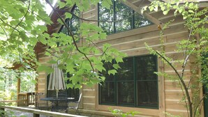 A wooden cabin with a deck, large windows, and outdoor furniture. - Very private luxury log home - Now with free 5G Wi-Fi! (Millboro)