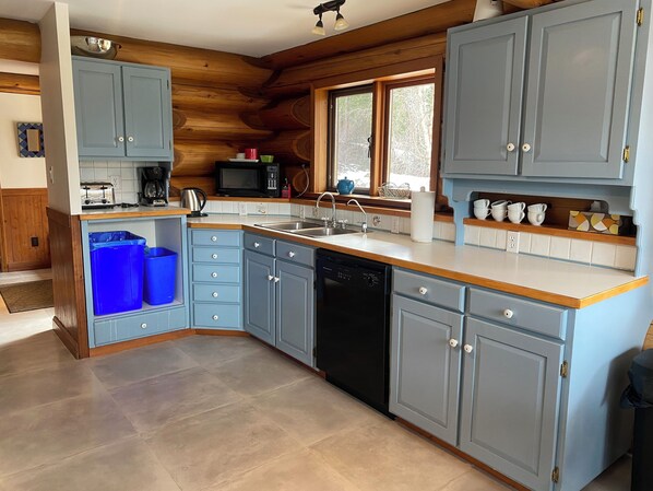 A modern kitchen with blue cabinets, a dishwasher, and a sink. - Log Home Getaway with Incredible Mountain Views (Golden)