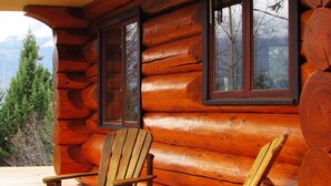 Una baita di legno con due poltrone Adirondack su un pontile di legno.