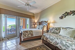 A bedroom with a bed, a sofa, a ceiling fan, and a view of the outdoors. - Stunning First-Floor Turtle Dunes Villa! Just Steps from Pool and Ocean! (Fernandina Beach)
