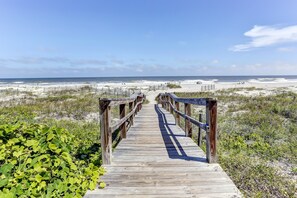 A wooden boardwalk leading to a beach with a clear sky. - Stunning First-Floor Turtle Dunes Villa! Just Steps from Pool and Ocean! (Fernandina Beach)