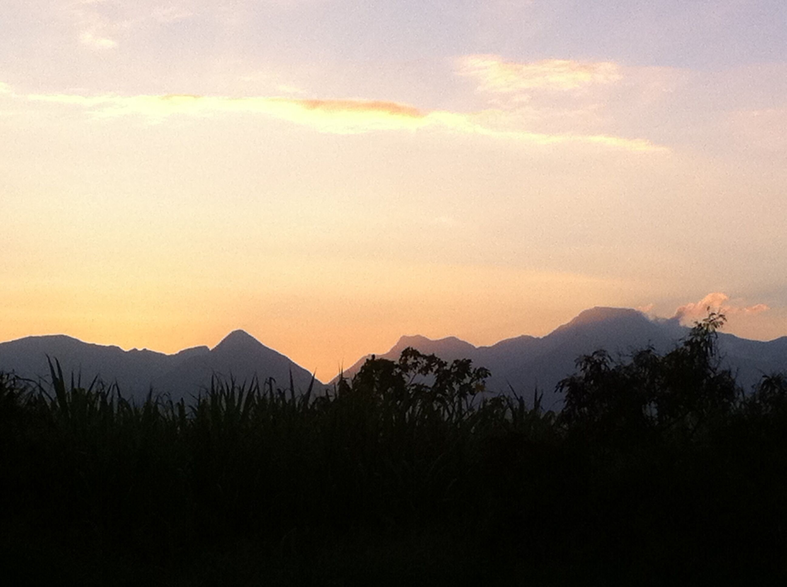A mountain range silhouette against a sunset sky.