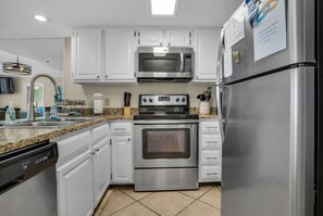 Equipped with a microwave, oven, and refrigerator, this kitchen offers a dishwasher and ample counter space.