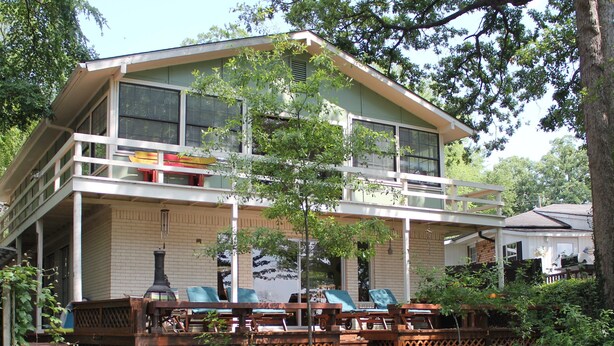 A two-story house with a balcony, outdoor seating area, and a garden. - Almost Seaside - Waterfront Paradise On Cedar Creek Lake! (Gun Barrel City)