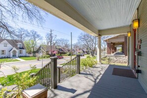 Guests can enjoy a covered porch with a railing, adjacent to a charming entrance.