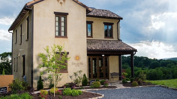 A two-story building with a beige facade, a covered porch, and a sign reading "Villa del Sole."