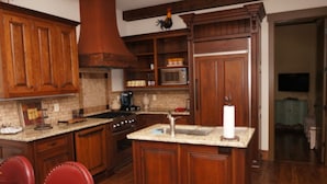 A kitchen with wooden cabinets, a stove, a microwave, and a sink.