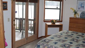 A bedroom with a bed, a wooden desk, a window with a view, and a door leading to an outdoor deck. - On Rainbow Lake, 3 bedroom 2 1/2 baths/Free WiFi, 65 inch tv, Pinetop-Lakeside. (Pinetop- Lakeside)