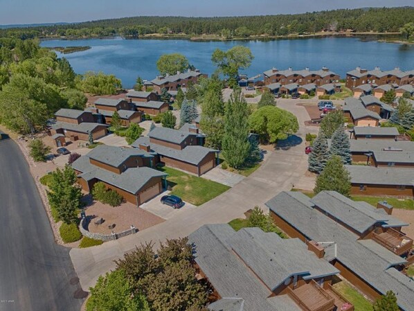 Un conjunto de cabañas con vistas al lago, rodeadas de vegetación y un cielo despejado.