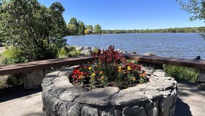 A stone planter with colorful flowers and a wooden bench overlooking a lake. - On Rainbow Lake, 3 bedroom 2 1/2 baths/Free WiFi, 65 inch tv, Pinetop-Lakeside. (Pinetop- Lakeside)
