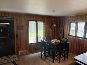 A dining area with a wooden interior, a deer head mounted on the wall, and a sign that reads "GO JAC".