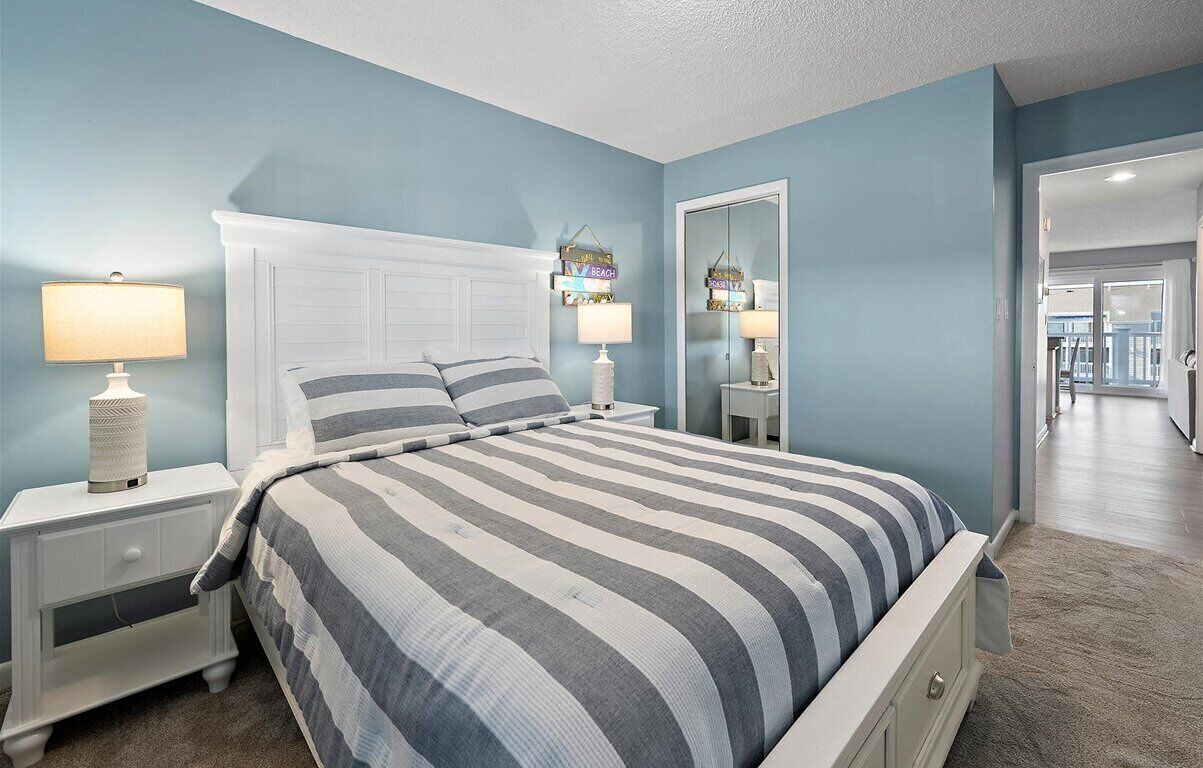 Een slaapkamer met een bed, nachtkastjes en een spiegel.