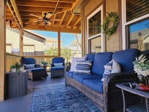A covered patio with wicker furniture, a ceiling fan, and a view of neighboring houses. - 1940s Vintage Home meets comfortable beach retreat (Galveston)