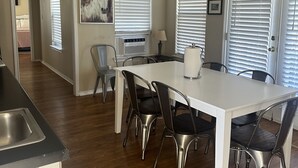 A modern kitchen with a white countertop, stainless steel sink, and a ceiling fan. - Green House on the River, Walk to Gruene Hall! (NEW BRAUNFELS)