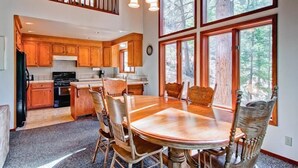 A spacious kitchen with wooden cabinets and a large dining table surrounded by chairs.