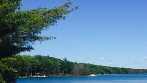 A lakeside scene with a clear sky, a dock, and two kayaks on the shore. - Hidden Springs on Long Lake  -  Sleeping Bear Dunes National Lakeshore (Honor)