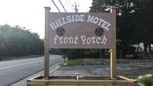 A wooden sign for Hillside Motel's front porch area. - Hillside Motel (Lake George)