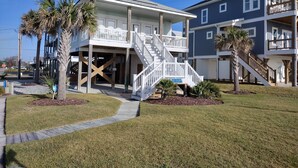 A two-story beachfront property with a covered porch, wooden deck, and a staircase leading to the upper level. - "The Palms" Oceanfront on Topsail Island, 2 BR - 2 BA Beach House - Awesome View (North Topsail Beach)