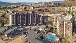 Un immeuble résidentiel à plusieurs étages doté d’une cour intérieure, d’une piscine et offrant une vue sur le paysage environnant.