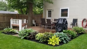 A backyard with a patio, a covered table, and a wooden deck. - Cozy Escape in Pettaquamscutt Neighborhood - Your Ideal Narragansett Getaway (Narragansett)