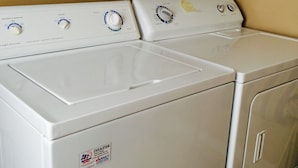 A front view of a white, stainless steel front-loading washer and dryer unit with a control panel featuring multiple dials and buttons. - Accepting reservations for 2027 summer! (Cody)