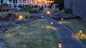 A two-story house with a porch, surrounded by a forested area. - Tide Cove Beachhouse in Poulsbo (Poulsbo)