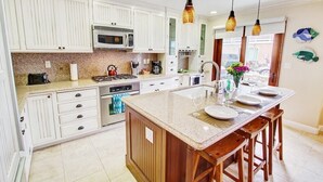 A modern kitchen with white cabinets, a central island, and pendant lighting. - Beach1Min Disney25Min Parking W/D Bikes Fast WiFi (Newport Beach)