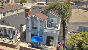 A two-story house with a balcony, a swimming pool, and a flag. - Beach1Min Disney25Min Parking W/D Bikes Fast WiFi (Newport Beach)