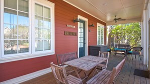A covered patio with wooden furniture, a grill, and a sign reading "SALTY AIR RETREAT".