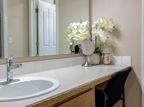 A bathroom with a white sink, a mirror, and a vase with white flowers. - READY IN MERIDIAN.. RELO SPECIALISTS, GOLF COURSE COMMUNITY (Meridian)