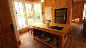 Eine Küche mit Holzwänden, einem großen Fenster und einem eingebauten Herd.