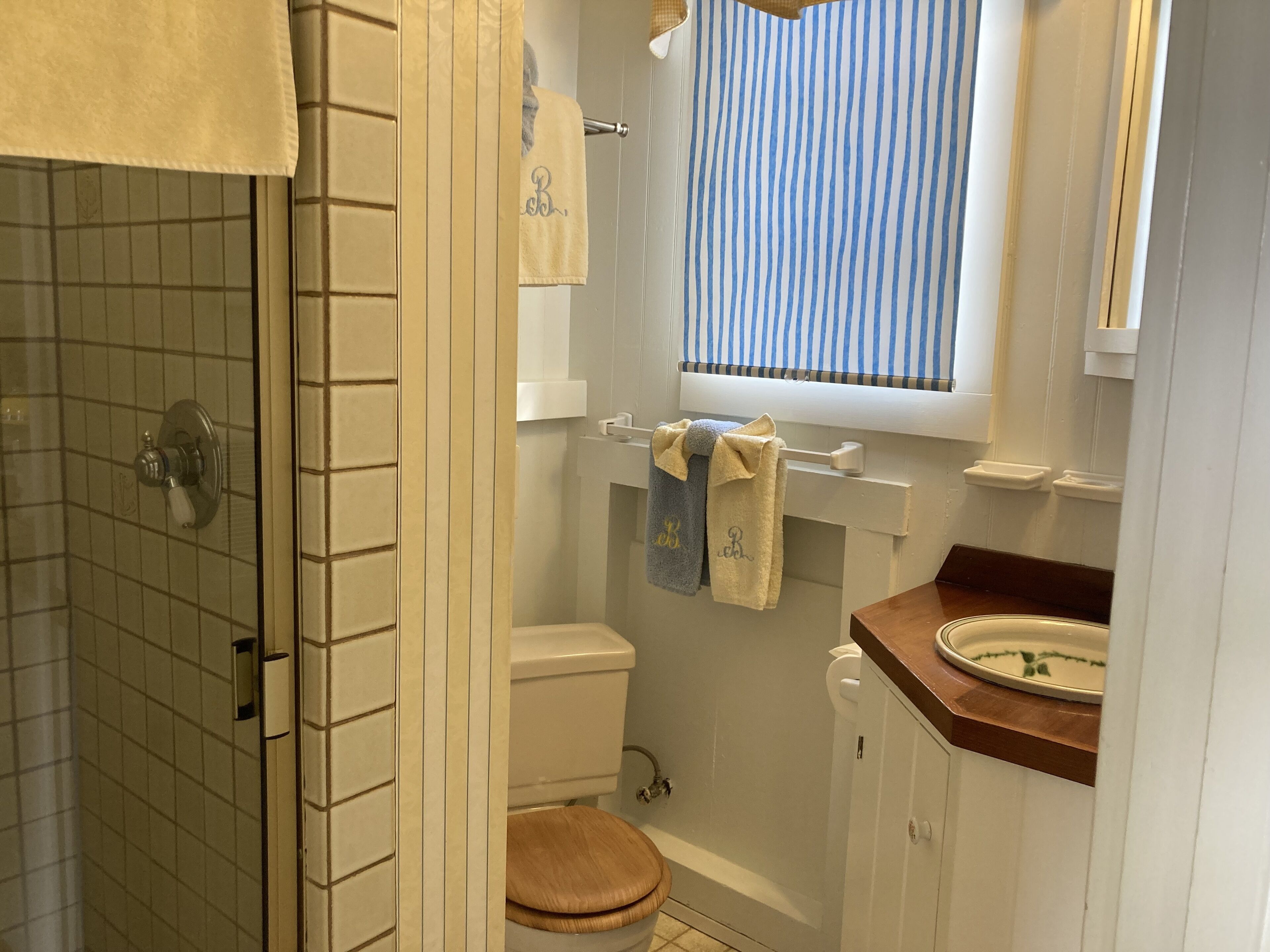 A bathroom with a shower, toilet, and sink.