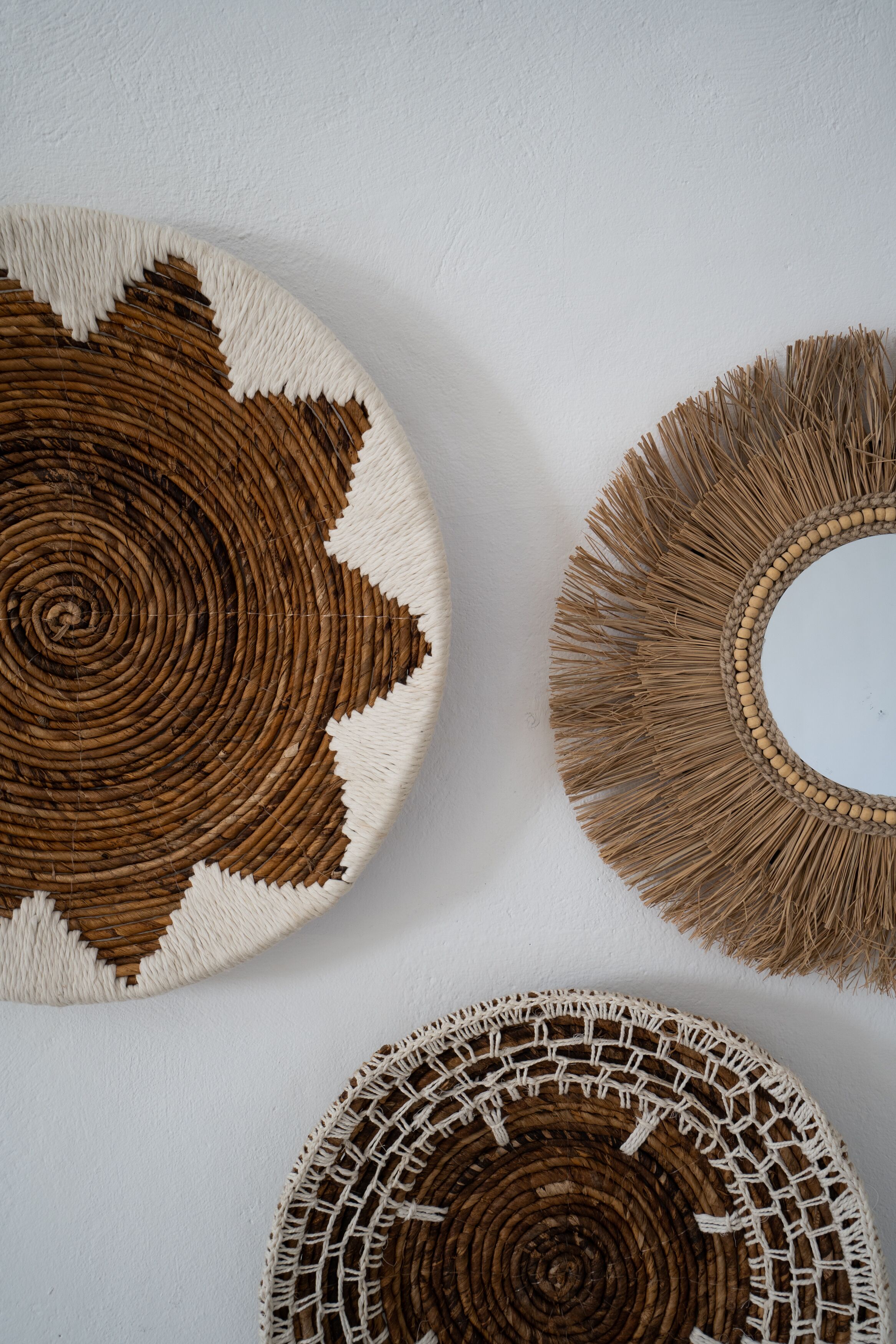Three circular woven wall decorations with different patterns and textures.