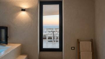 A room with a view of outdoor seating, a wooden ladder, and a light fixture.