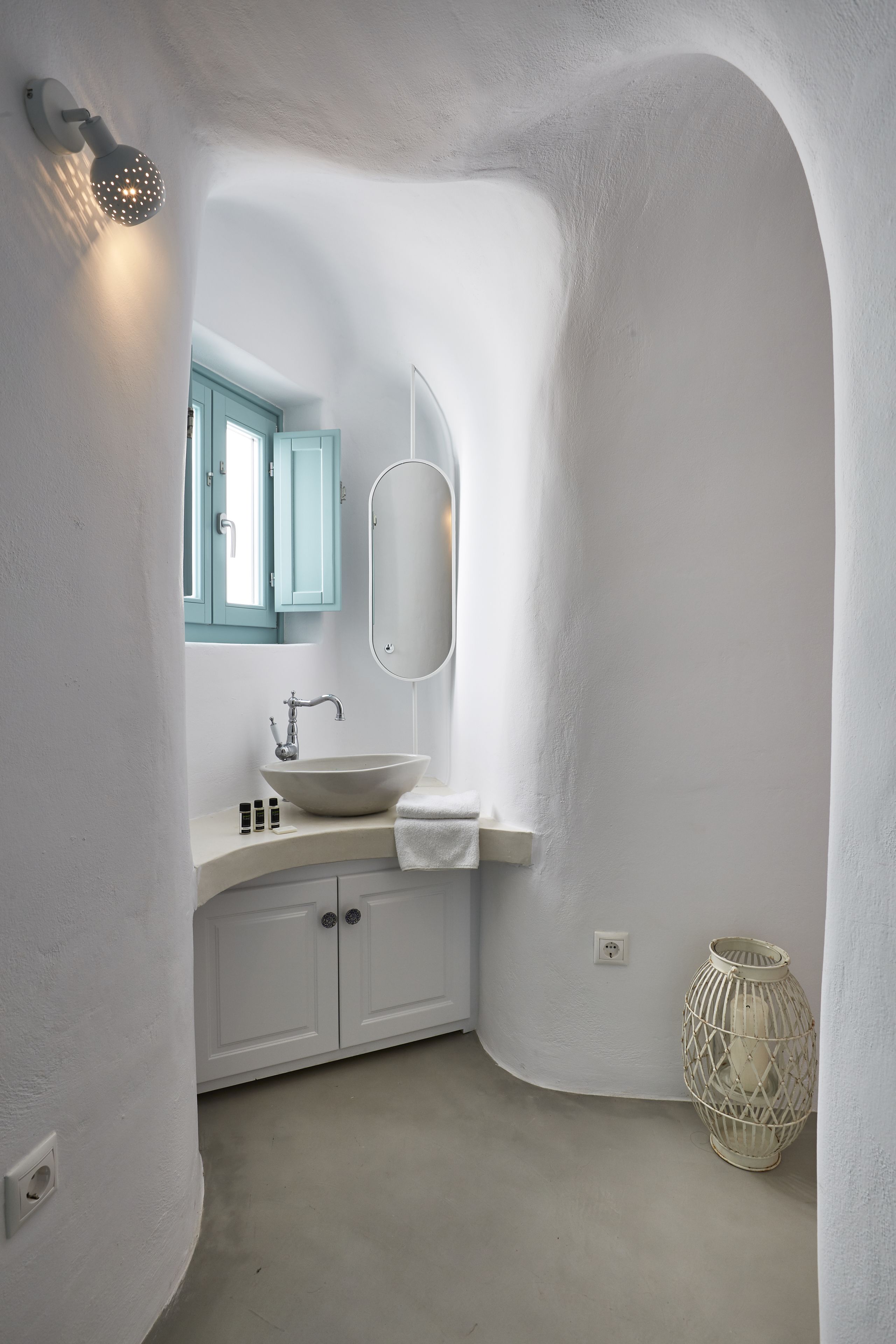 A bathroom with a white sink, a mirror, and a light fixture.