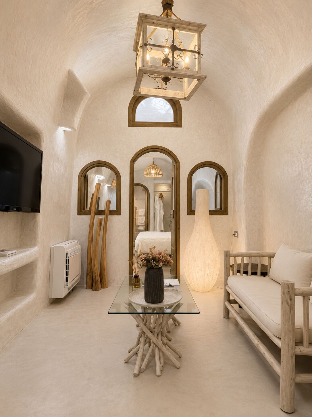 A room with a television, a wooden chair, a glass table with a vase, and a unique ceiling design.