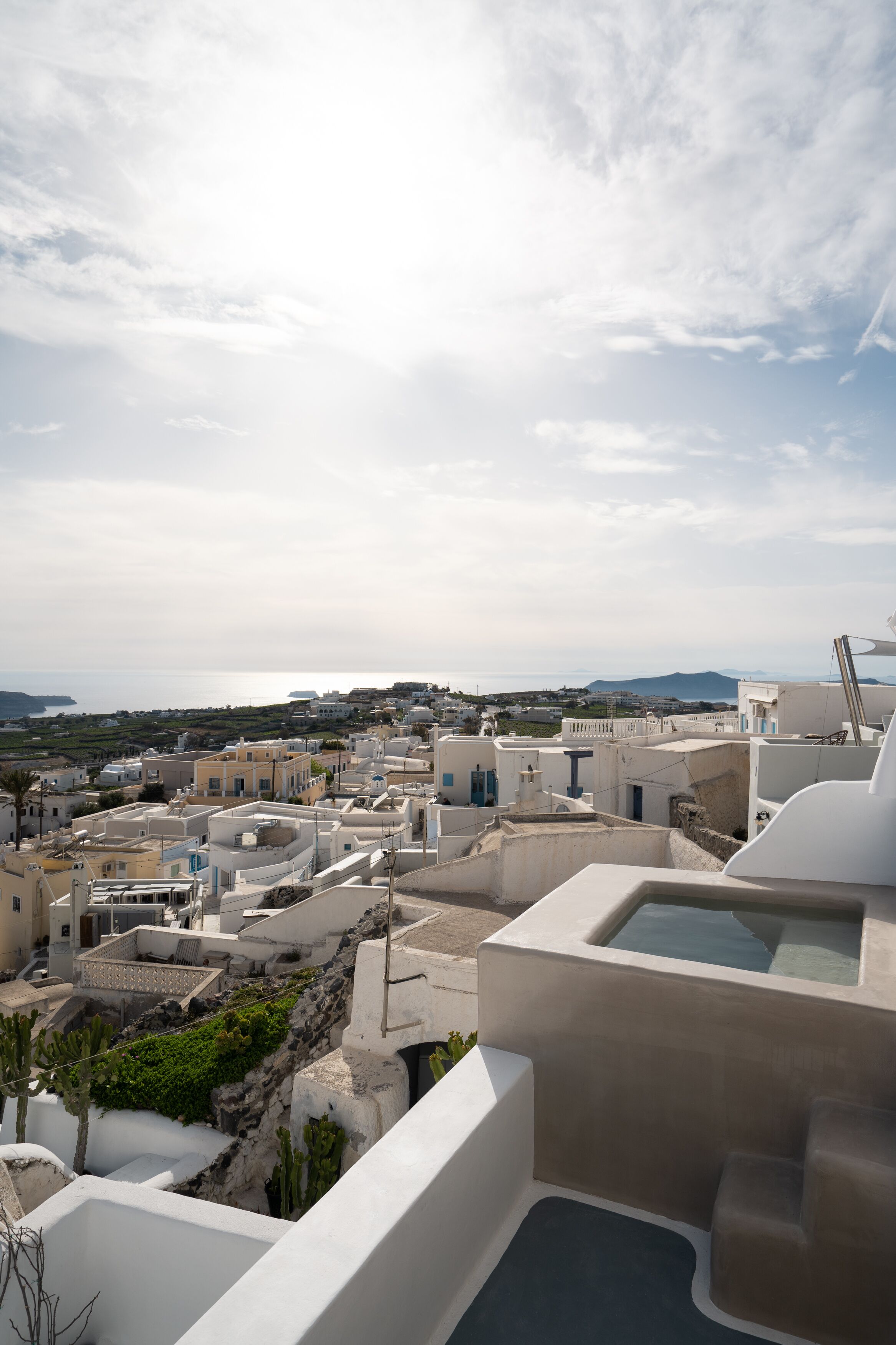 A coastal town with white buildings, a clear sky, and a view of the sea.
