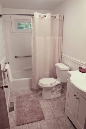 Ein Badezimmer mit Badewanne, Toilette und Duschvorhang.