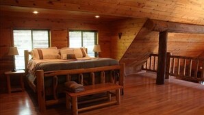 Une chambre dans une cabane en bois, avec un lit, un banc et deux lampes.