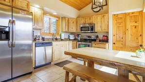 A modern kitchen with wooden cabinets, stainless steel appliances, and a central island. - Pikes Peak Ranch - Elk Ridge Cabin (Woodland Park)