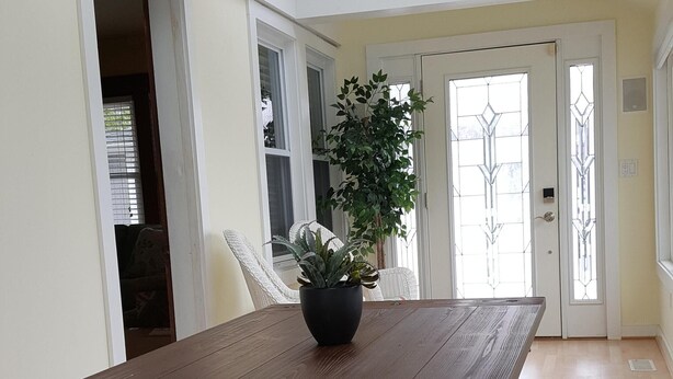 Ein Essbereich mit einem Holztisch, Bänken und einem Blumentopf.