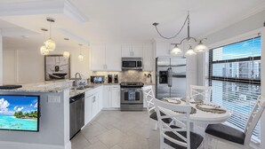 Una cocina moderna con armarios blancos, electrodomésticos de acero inoxidable y una isla grande con asientos.