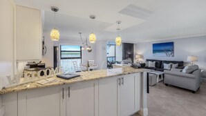 Una cocina moderna con una isla central, iluminación colgante y vistas al exterior.