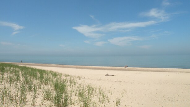 A beach with sand and sparse vegetation. - 300 paces-1/2 Block to McKinley Beach, Fire Pit, Screened Gazebo,
Outdoor Shower (Union Pier)