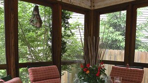 A covered patio with a glass table set for four, surrounded by patterned chairs. - 300 paces-1/2 Block to McKinley Beach, Fire Pit, Screened Gazebo,
Outdoor Shower (Union Pier)