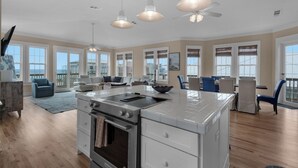 A spacious kitchen with an island, a dining area, and a seating area with a view.
