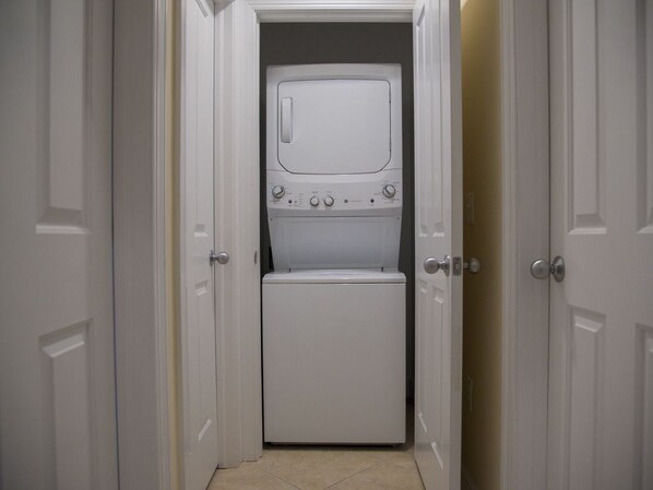 A laundry room with a washer and dryer, a door, and a tiled floor. - SPECTACULAR Indigo Reef Waterfront Home #41 - Marathon, Florida (Marathon)