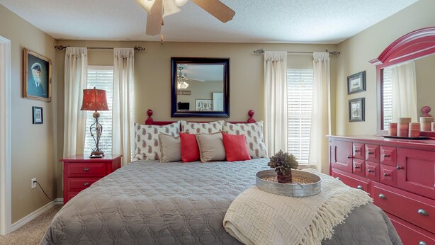 A bedroom with a bed, a ceiling fan, a dresser, and a mirror. - MERMAID - Largest Heated Pool, Walk to Private Beach, GolfCart, Pet Friendly. (Miramar Beach)